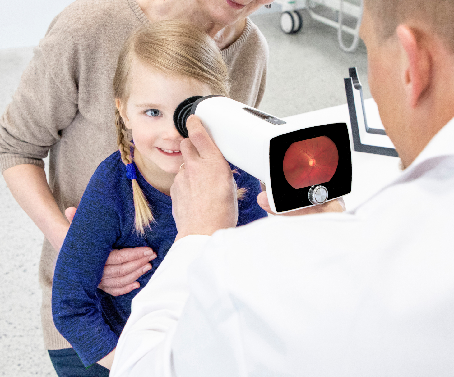 Fundus imaging of a pediatrics patient who is sitting on her grandmother's lap.
