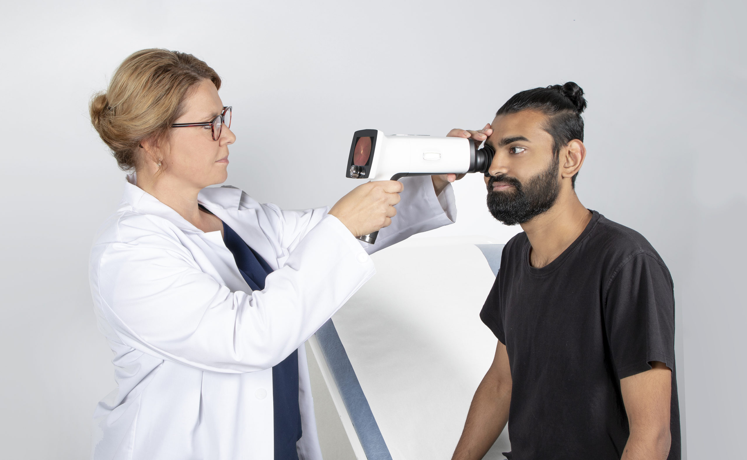 Doctor using Optomed Aurora for a male patient