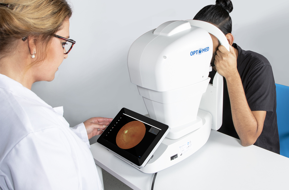 Doctor looking at a retinal image taken with Optomed Polaris, a fully automatic non-mydriatic tabletop fundus camera.