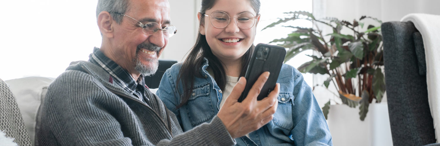 Grandfather and grand daughter looking together mobile phone