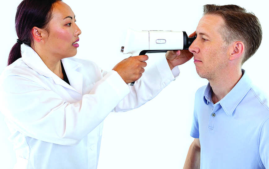Doctor imaging patients eye fundus with Optomed Aurora