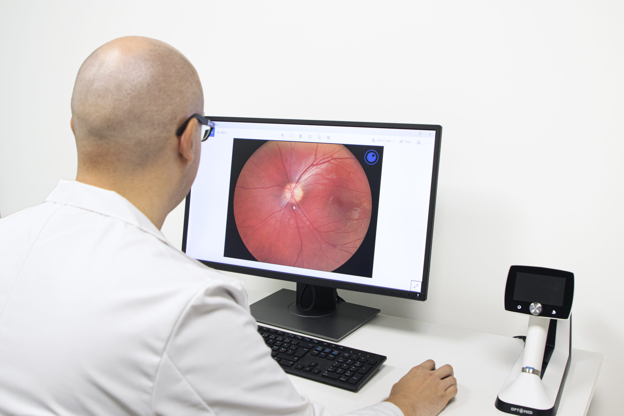 Documentation of fundus findings. Doctor looking at the fundus image taken with Optomed Aurora IQ.